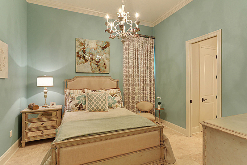 Cette image montre une chambre d'amis traditionnelle de taille moyenne avec un mur bleu, un sol en travertin, aucune cheminée et un sol beige.
