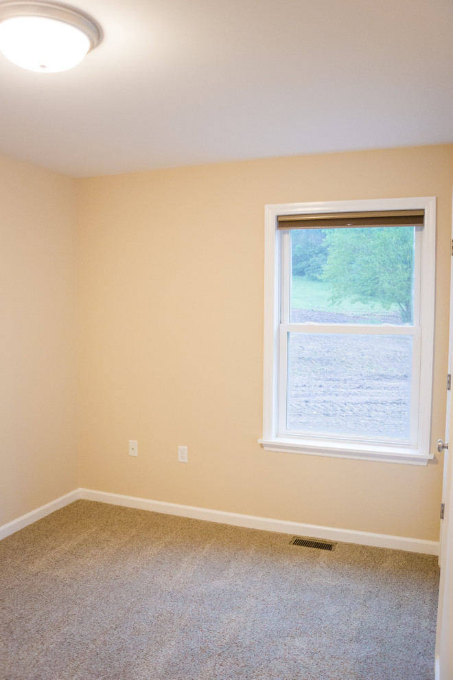 Immagine di una camera degli ospiti minimal di medie dimensioni con pareti beige, moquette e nessun camino