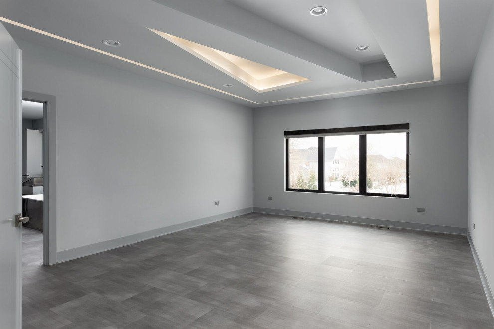 Réalisation d'une grande chambre parentale minimaliste avec un mur gris et un sol gris.
