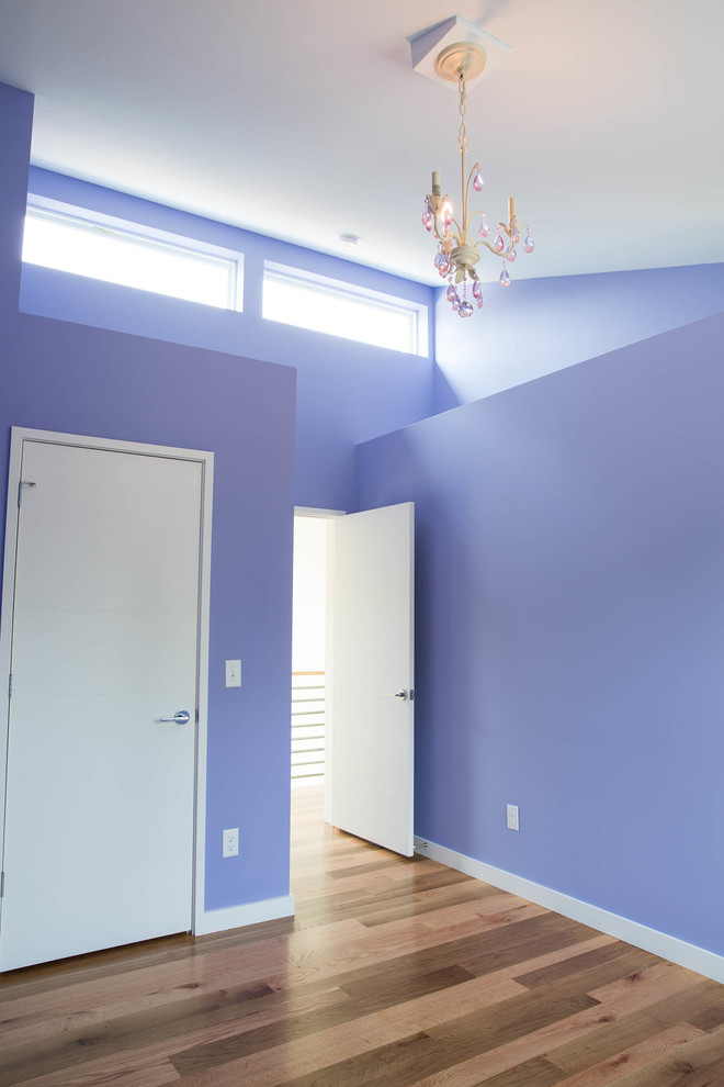 Foto di una camera degli ospiti minimalista di medie dimensioni con pavimento in legno massello medio, pavimento marrone e pareti viola
