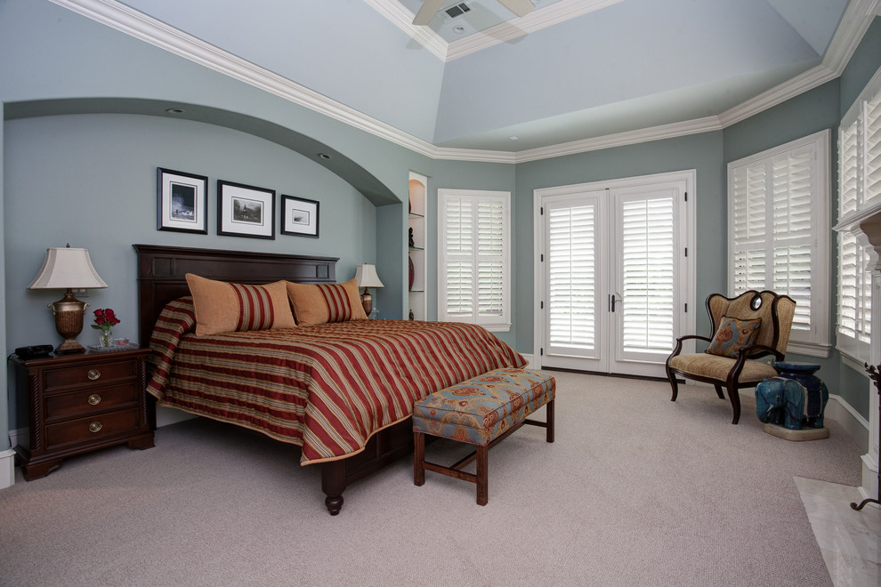 Ejemplo de dormitorio principal clásico grande con paredes azules, moqueta, todas las chimeneas, marco de chimenea de yeso y suelo beige