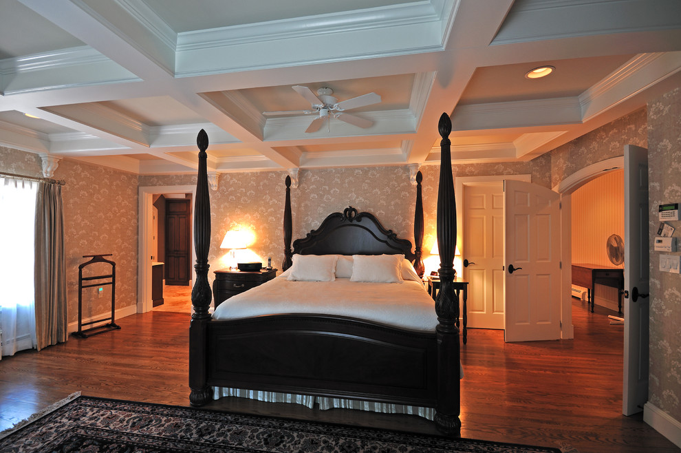 Diseño de dormitorio principal tradicional de tamaño medio con paredes beige, suelo de madera oscura, todas las chimeneas y marco de chimenea de piedra