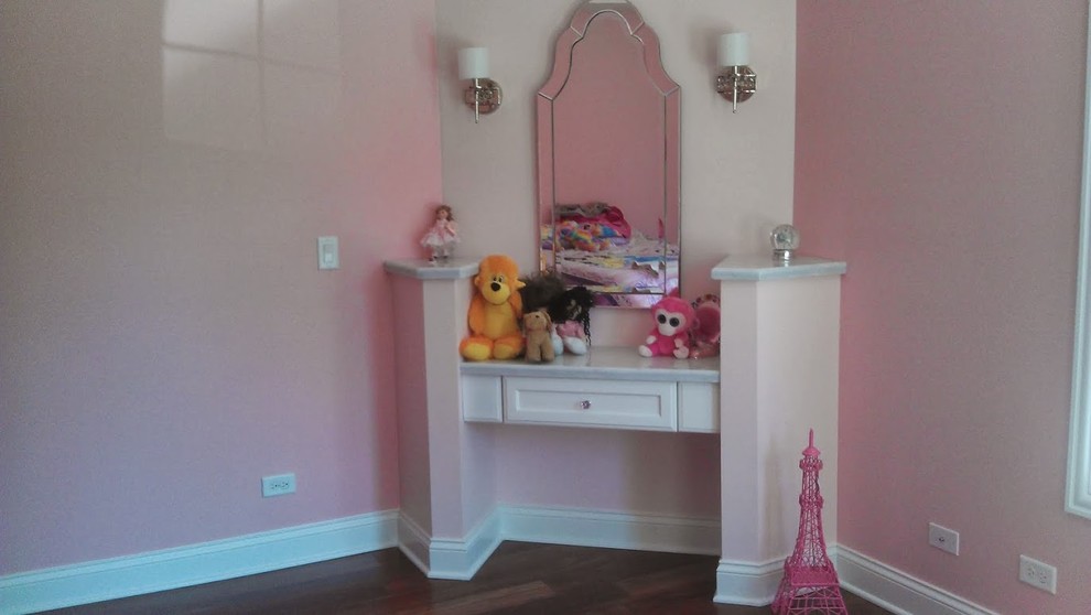 Cette image montre une petite chambre d'amis avec un mur rose et parquet foncé.
