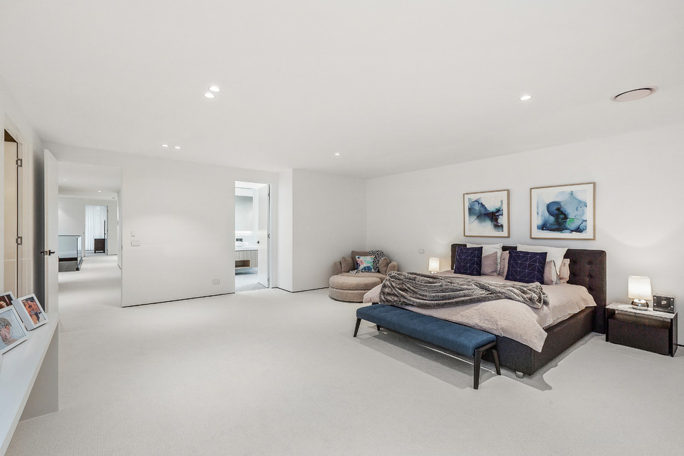 Стильный дизайн: большая хозяйская спальня в современном стиле с белыми стенами, ковровым покрытием и белым полом - последний тренд