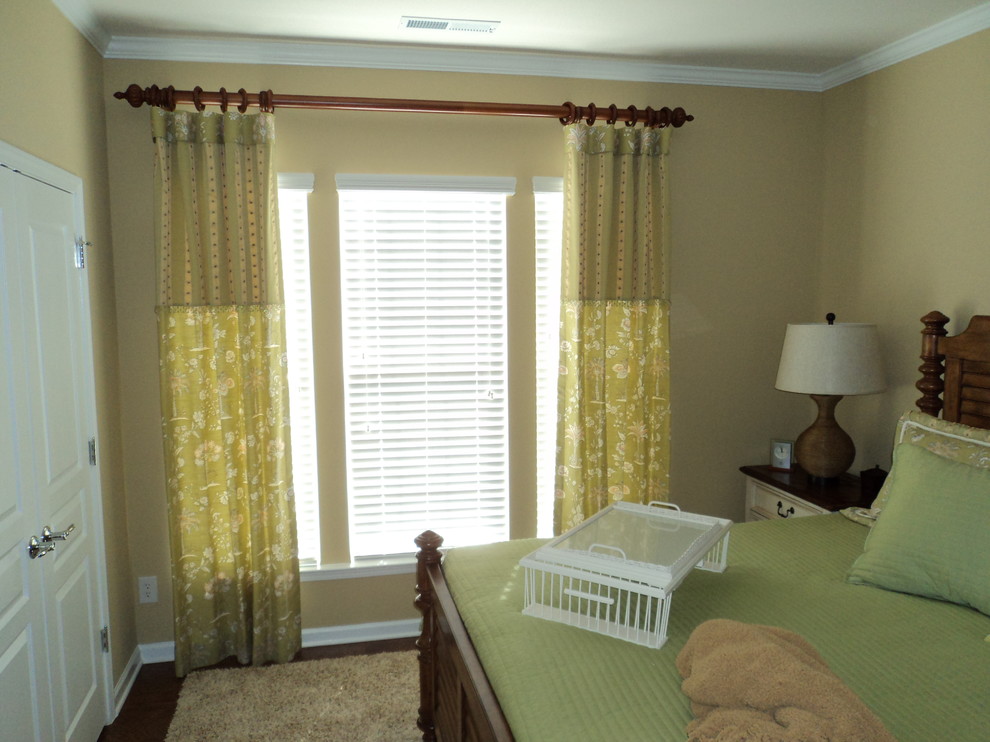 Idéer för ett mellanstort klassiskt sovrum, med mellanmörkt trägolv och gula väggar