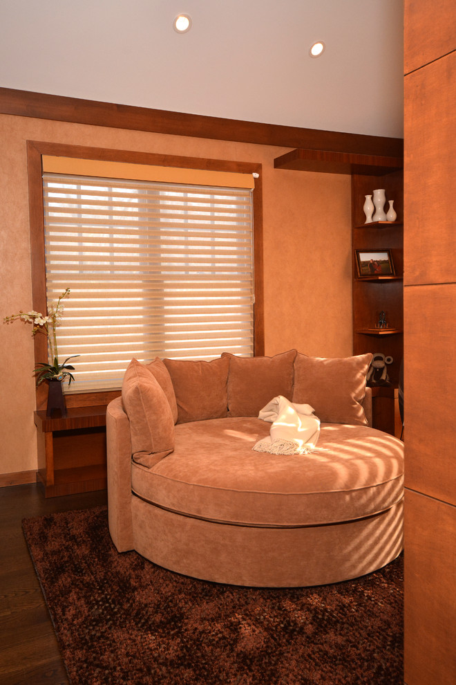 Стильный дизайн: хозяйская спальня среднего размера в современном стиле с оранжевыми стенами, темным паркетным полом, двусторонним камином, фасадом камина из камня и коричневым полом - последний тренд
