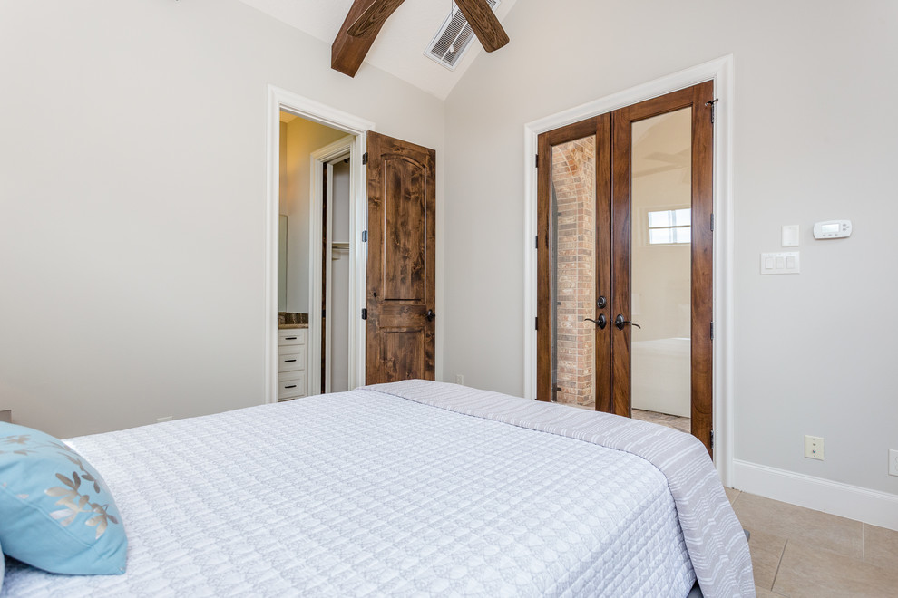 Ejemplo de habitación de invitados mediterránea grande con paredes grises, suelo de piedra caliza y suelo beige