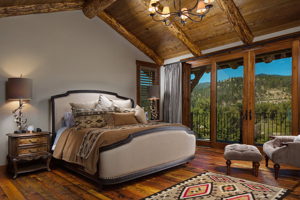 Foto de dormitorio rural con paredes grises, suelo de madera en tonos medios y suelo marrón