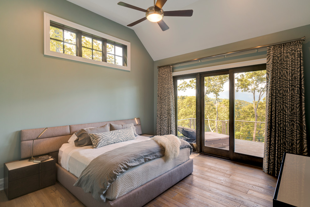 Imagen de dormitorio principal de estilo americano grande sin chimenea con paredes grises y suelo de madera clara