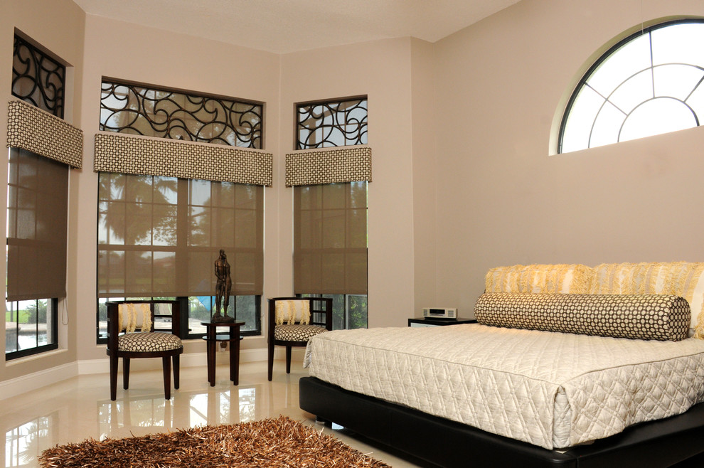 Modelo de dormitorio principal contemporáneo extra grande sin chimenea con paredes beige, suelo beige y suelo de baldosas de porcelana
