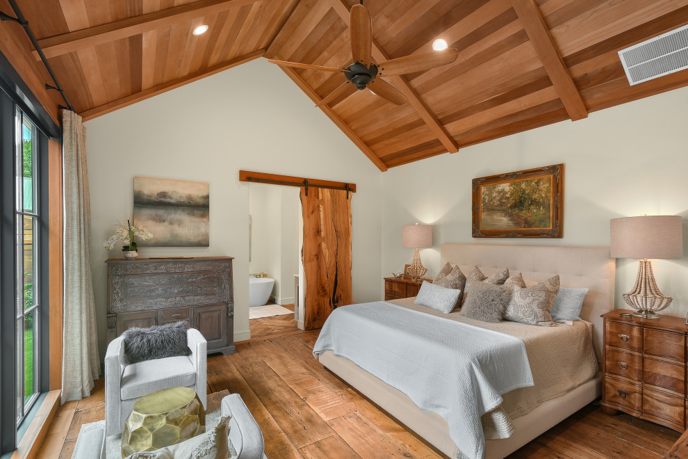 Cette photo montre une grande chambre parentale nature avec un mur blanc, un sol en bois brun et un plafond en bois.