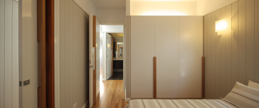 Пример оригинального дизайна: большая гостевая спальня (комната для гостей) в современном стиле с белыми стенами и паркетным полом среднего тона