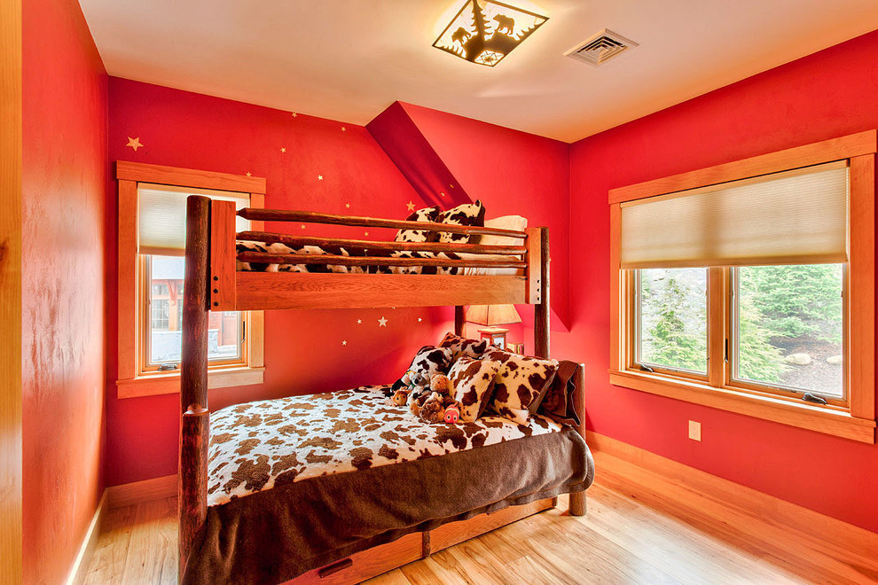 Diseño de habitación de invitados rústica de tamaño medio sin chimenea con paredes rojas, suelo de madera clara y suelo marrón