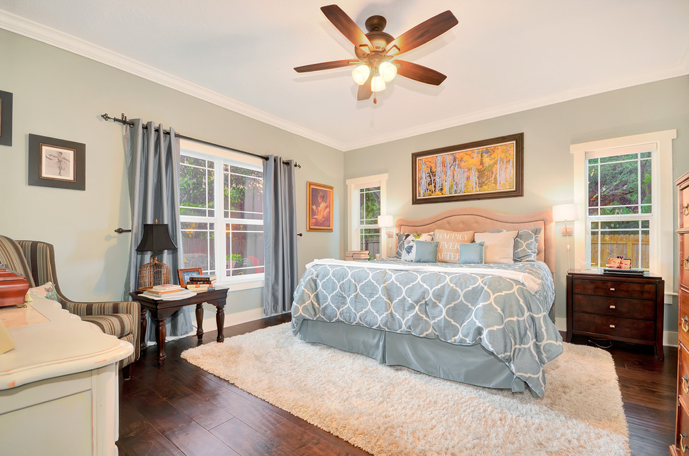 Ejemplo de dormitorio principal de estilo americano de tamaño medio sin chimenea con paredes grises, suelo de madera en tonos medios y suelo marrón