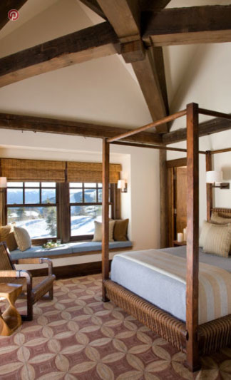 Modelo de dormitorio principal rústico extra grande con paredes beige, suelo de bambú, todas las chimeneas y marco de chimenea de piedra