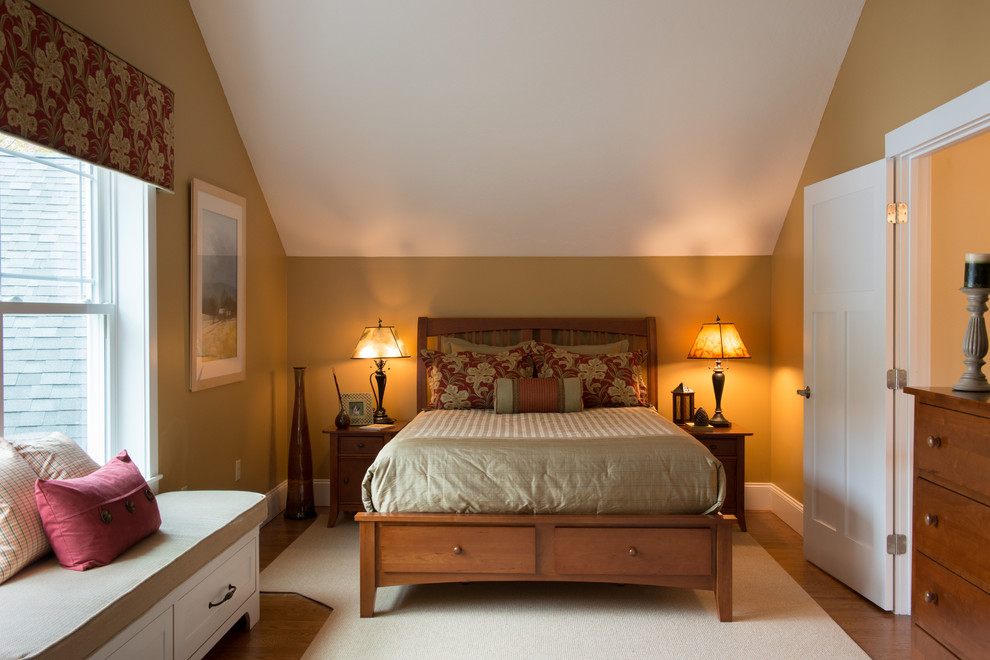 Modelo de dormitorio principal actual grande sin chimenea con suelo de madera clara y paredes beige
