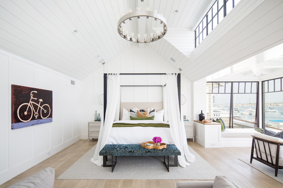 Diseño de dormitorio costero con paredes blancas, suelo de madera clara y suelo beige