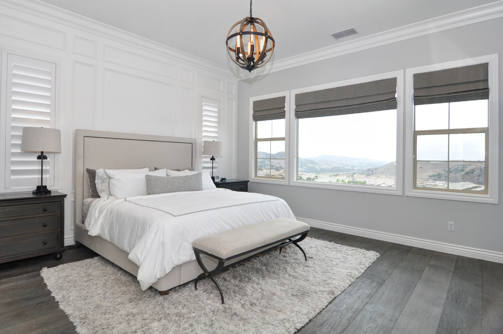 Klassisches Schlafzimmer mit grauer Wandfarbe, dunklem Holzboden und grauem Boden in Orange County