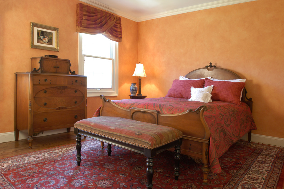 Design ideas for a medium sized traditional guest bedroom in Boston with orange walls and medium hardwood flooring.