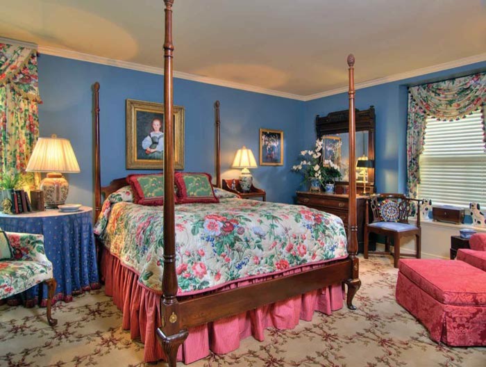 Esempio di una camera matrimoniale stile shabby di medie dimensioni con pareti blu, moquette e pavimento multicolore