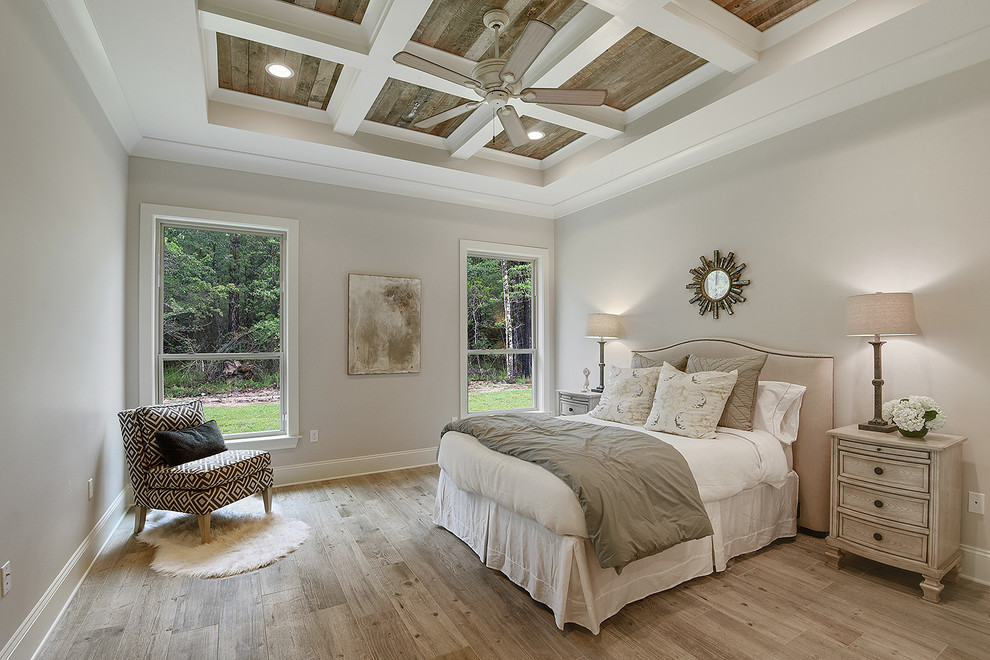 Diseño de dormitorio principal tradicional renovado de tamaño medio sin chimenea con paredes beige, suelo de madera clara y suelo beige