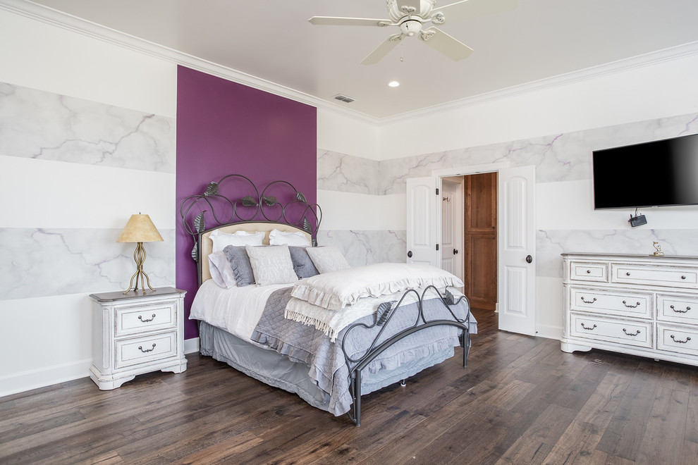 Traditional grey and purple bedroom in Austin with multi-coloured walls, dark hardwood flooring and brown floors.