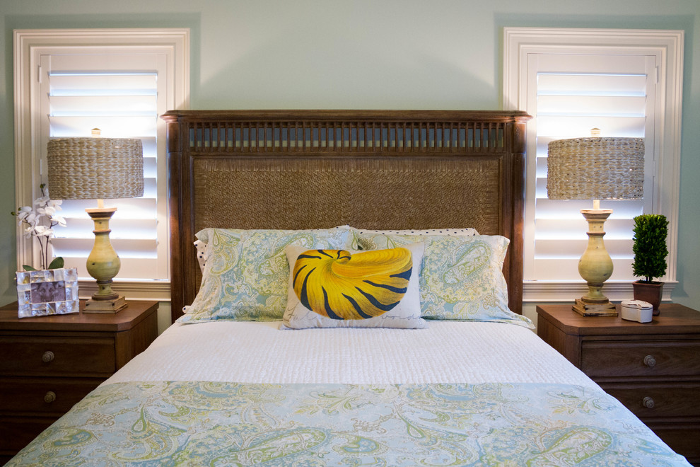 Modelo de habitación de invitados tropical grande con paredes azules, suelo de madera en tonos medios y suelo marrón