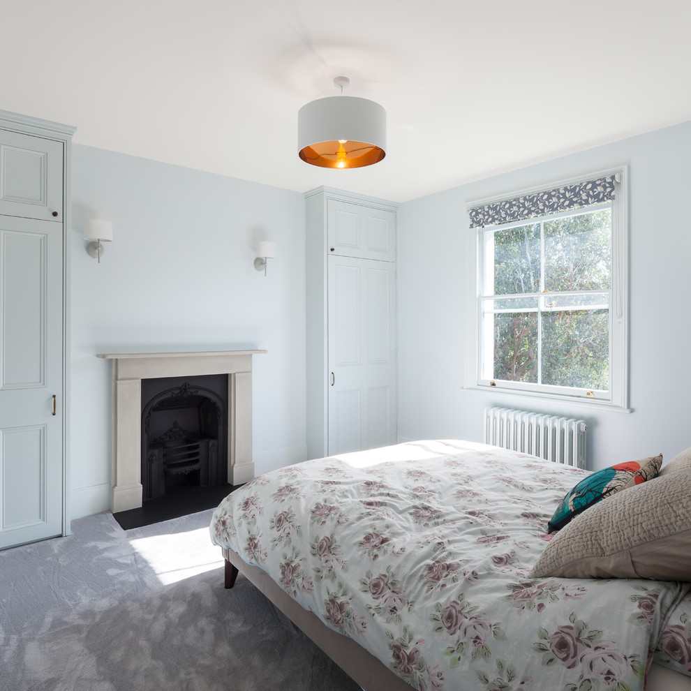 ロンドンにある中くらいなコンテンポラリースタイルのおしゃれな客用寝室 (青い壁、カーペット敷き、コーナー設置型暖炉、金属の暖炉まわり、紫の床) のレイアウト