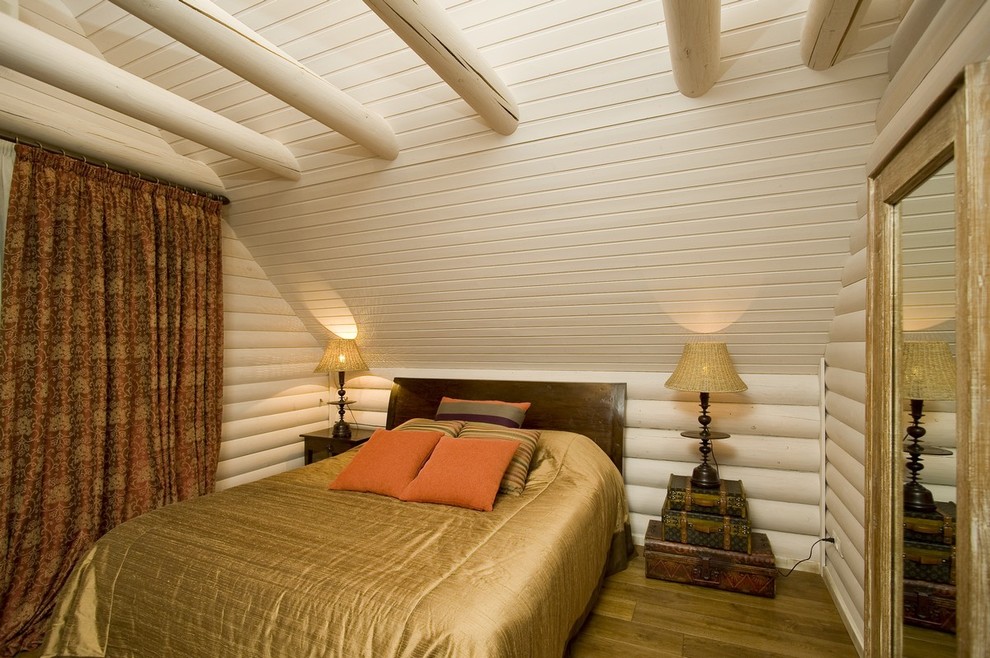 Imagen de dormitorio principal de estilo de casa de campo con paredes blancas y suelo de madera en tonos medios