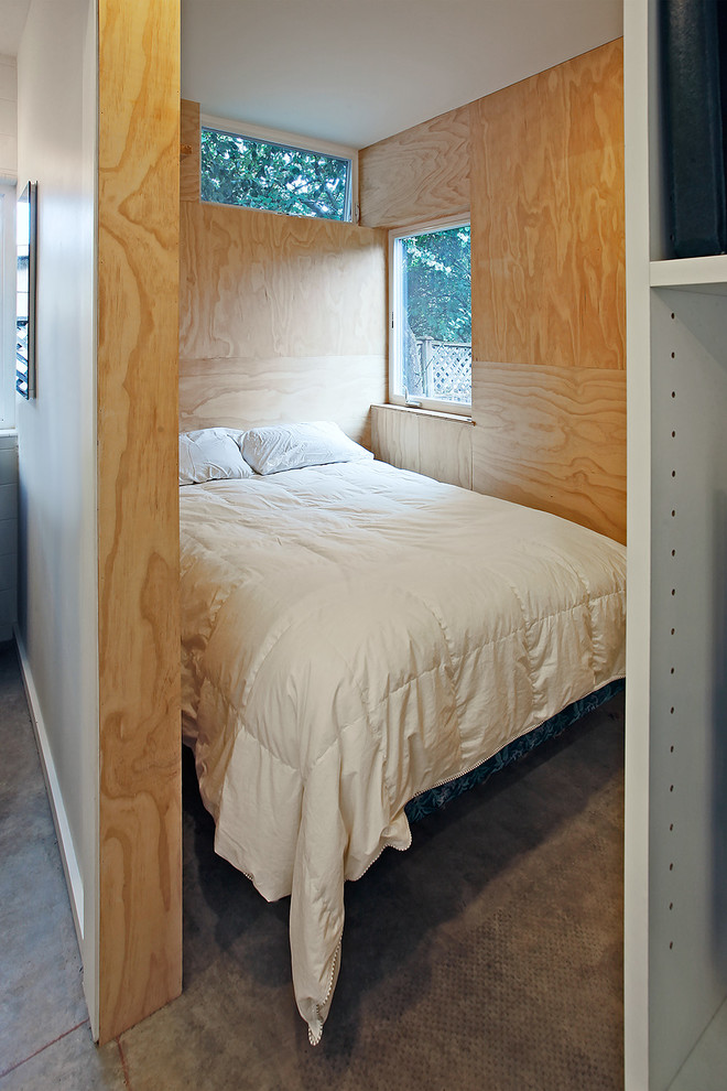 Foto de dormitorio contemporáneo pequeño con suelo de cemento