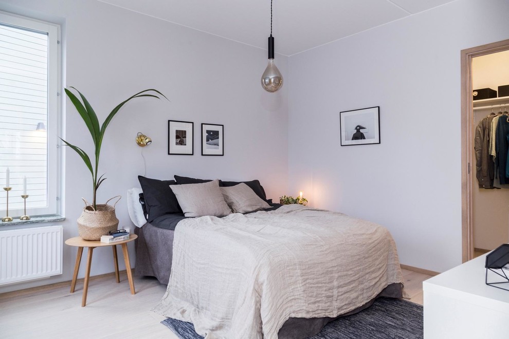 Réalisation d'une chambre nordique avec un mur gris, parquet clair et un sol beige.
