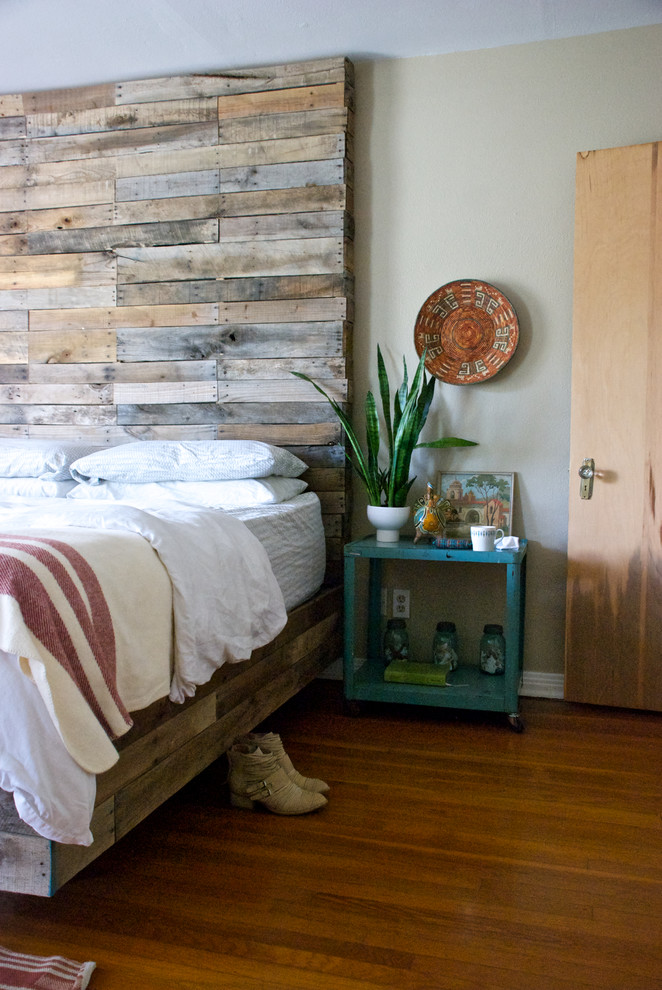 Idée de décoration pour une chambre bohème avec un mur gris et un sol en bois brun.