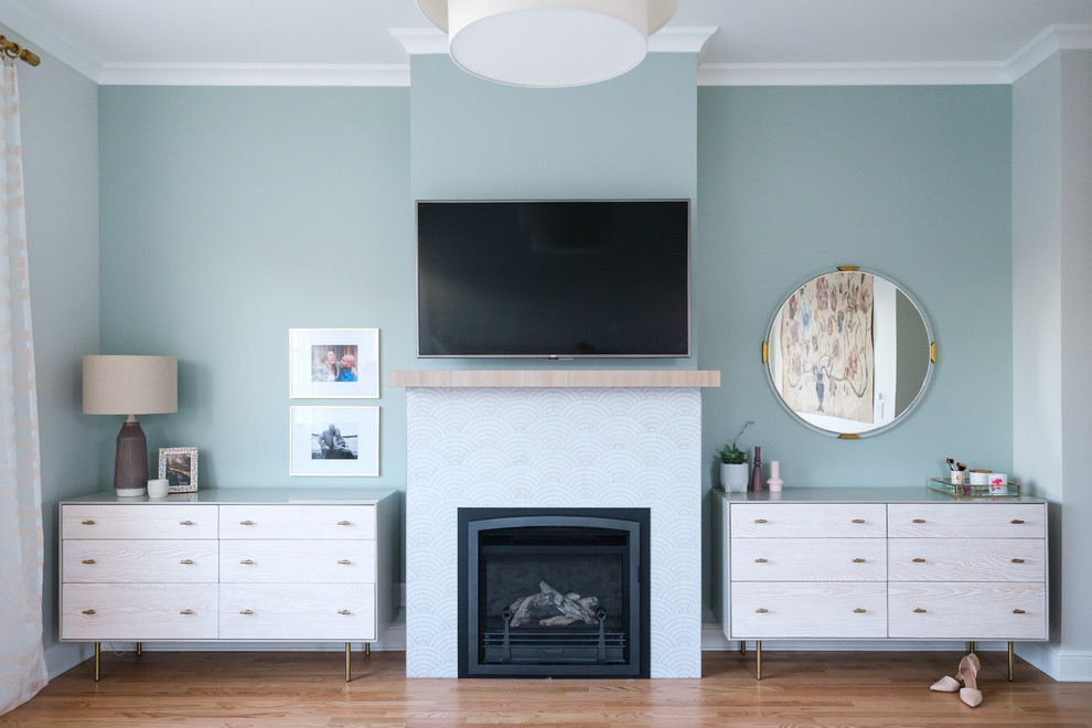 Aménagement d'une chambre classique avec une cheminée standard, un manteau de cheminée en carrelage, un mur bleu, un sol en bois brun et un sol marron.