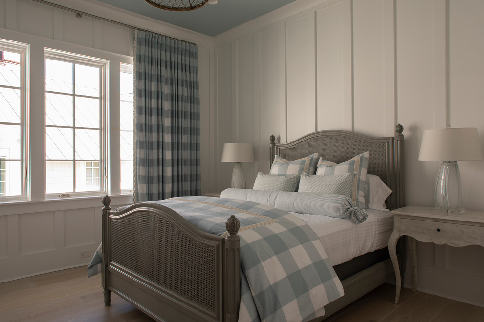 Foto de habitación de invitados costera grande con paredes blancas, suelo de madera en tonos medios y suelo marrón