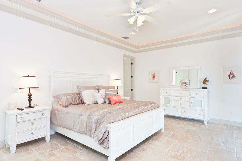 Diseño de dormitorio principal marinero grande con paredes blancas y suelo de travertino