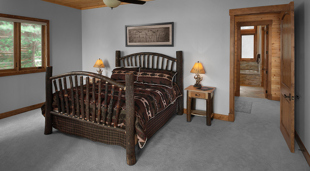 Modelo de dormitorio rústico grande con paredes grises y moqueta