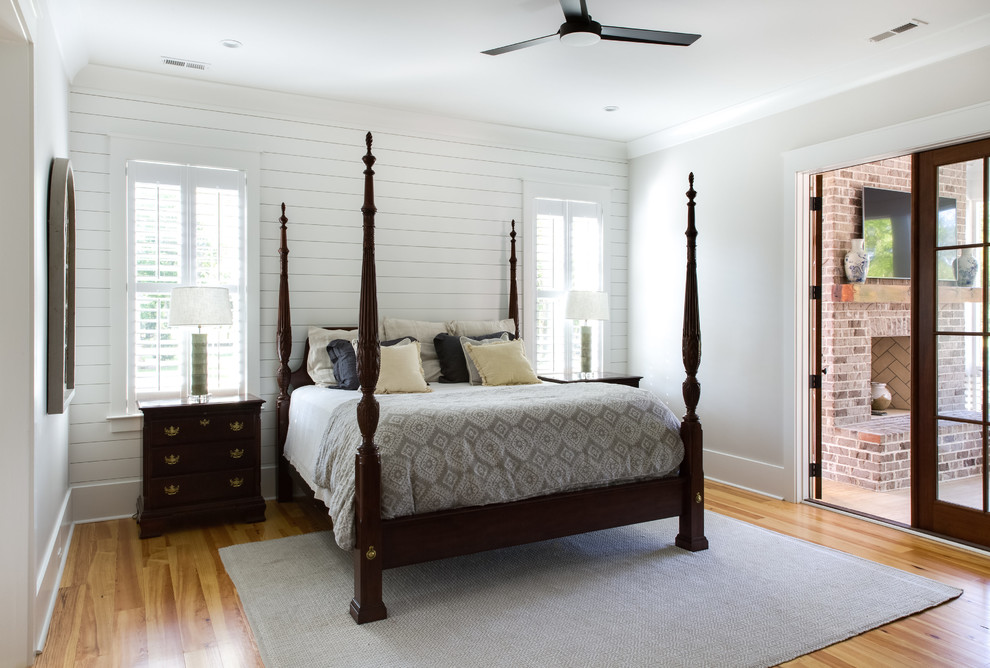 Cette image montre une chambre parentale traditionnelle de taille moyenne avec un mur blanc, un sol en bois brun et un sol beige.