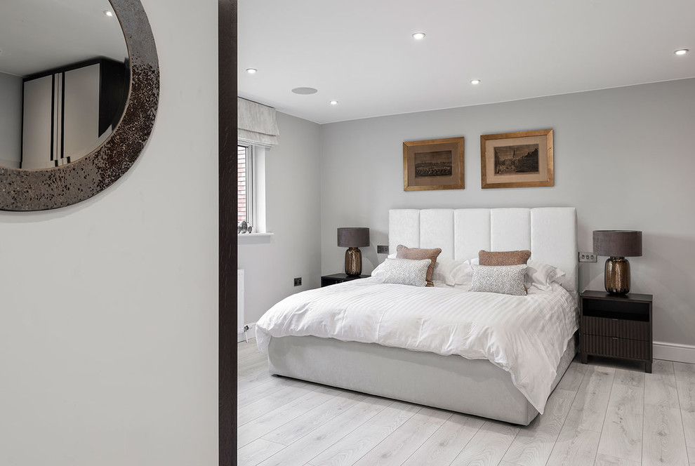 Medium sized contemporary master and grey and silver bedroom in Berkshire with grey walls, laminate floors and grey floors.