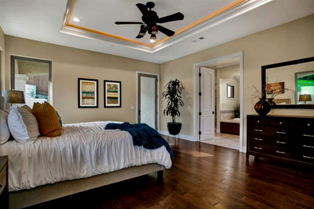 サンディエゴにある広い地中海スタイルのおしゃれな主寝室 (ベージュの壁、無垢フローリング、茶色い床) のインテリア