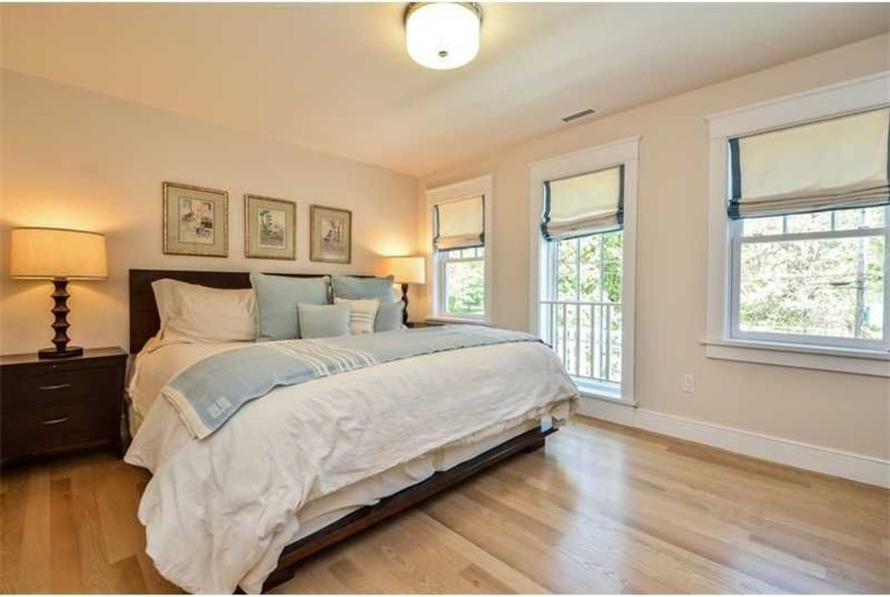 Modelo de habitación de invitados clásica renovada de tamaño medio con paredes beige y suelo de madera clara