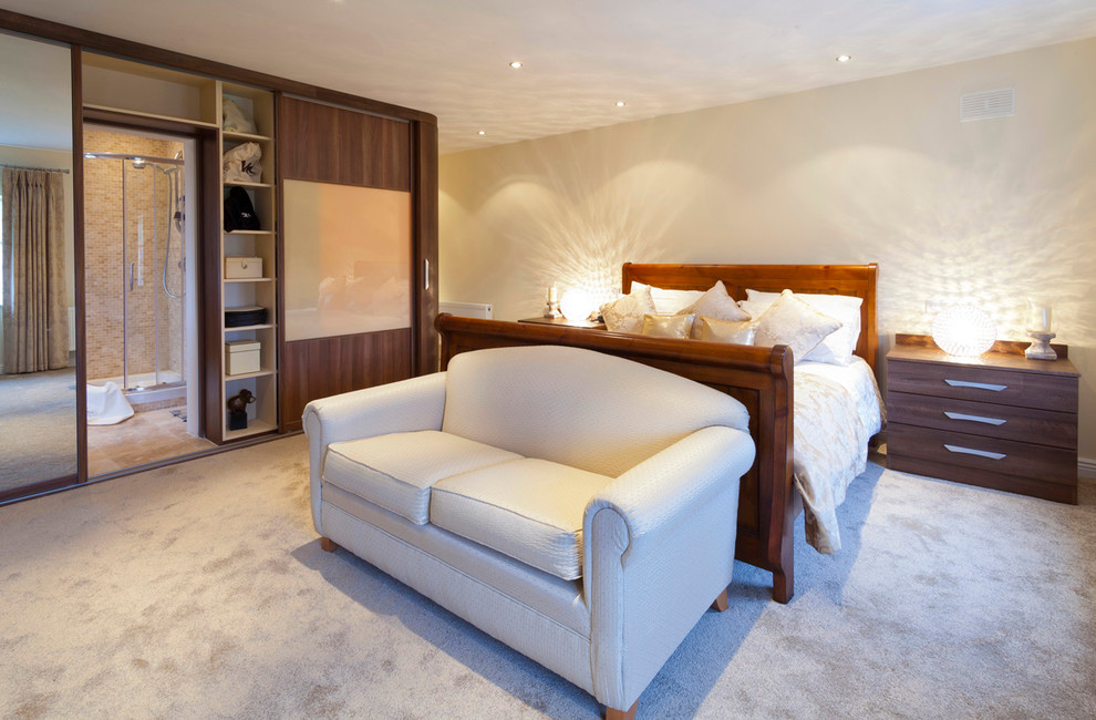 Example of a mid-sized trendy master carpeted bedroom design in Dublin with beige walls and no fireplace