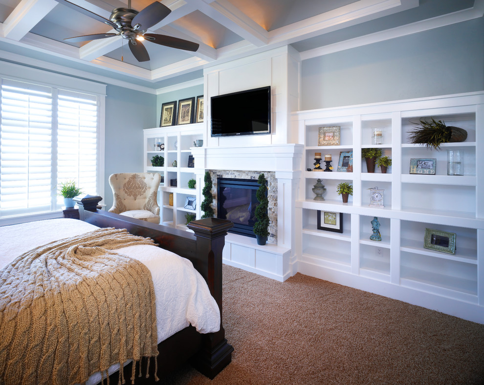 Idées déco pour une chambre classique de taille moyenne avec un mur bleu, une cheminée standard, un manteau de cheminée en pierre et un sol marron.