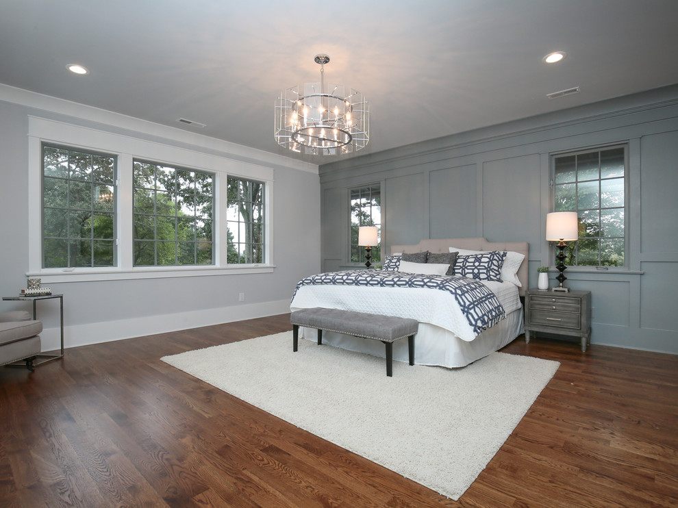 This is an example of a large classic master bedroom in Raleigh with grey walls and dark hardwood flooring.