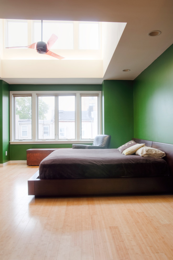 Esempio di una camera matrimoniale minimalista con pareti verdi, pavimento in bambù e nessun camino