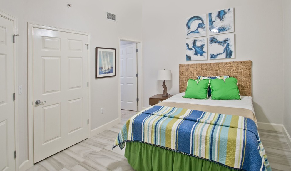 На фото: маленькая гостевая спальня (комната для гостей) в морском стиле с белыми стенами и полом из керамогранита для на участке и в саду с