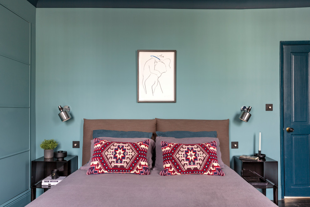 Modelo de dormitorio principal ecléctico de tamaño medio sin chimenea con paredes azules, suelo de madera oscura y suelo marrón