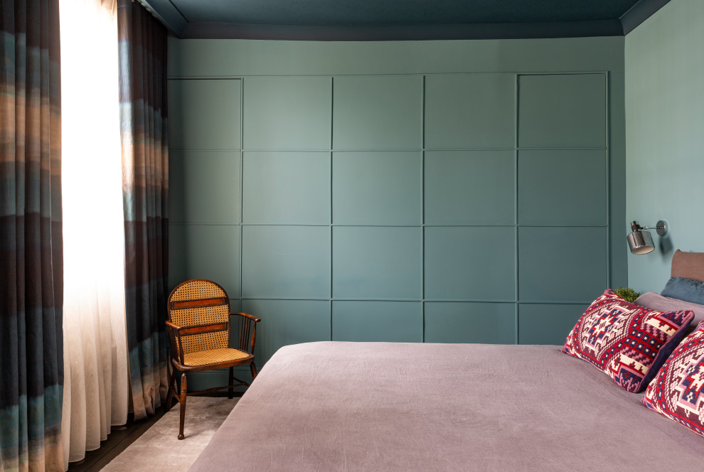 Diseño de dormitorio principal ecléctico de tamaño medio sin chimenea con paredes azules, suelo de madera oscura y suelo marrón