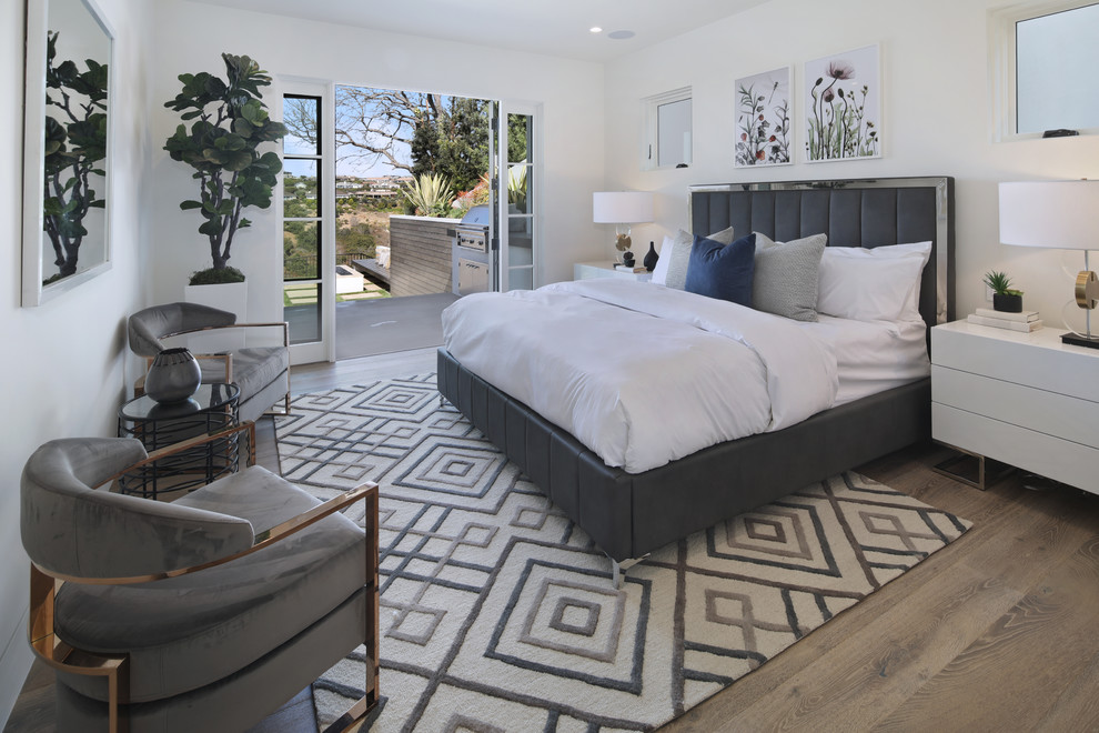 Ejemplo de dormitorio actual con paredes blancas, suelo de madera en tonos medios y suelo marrón