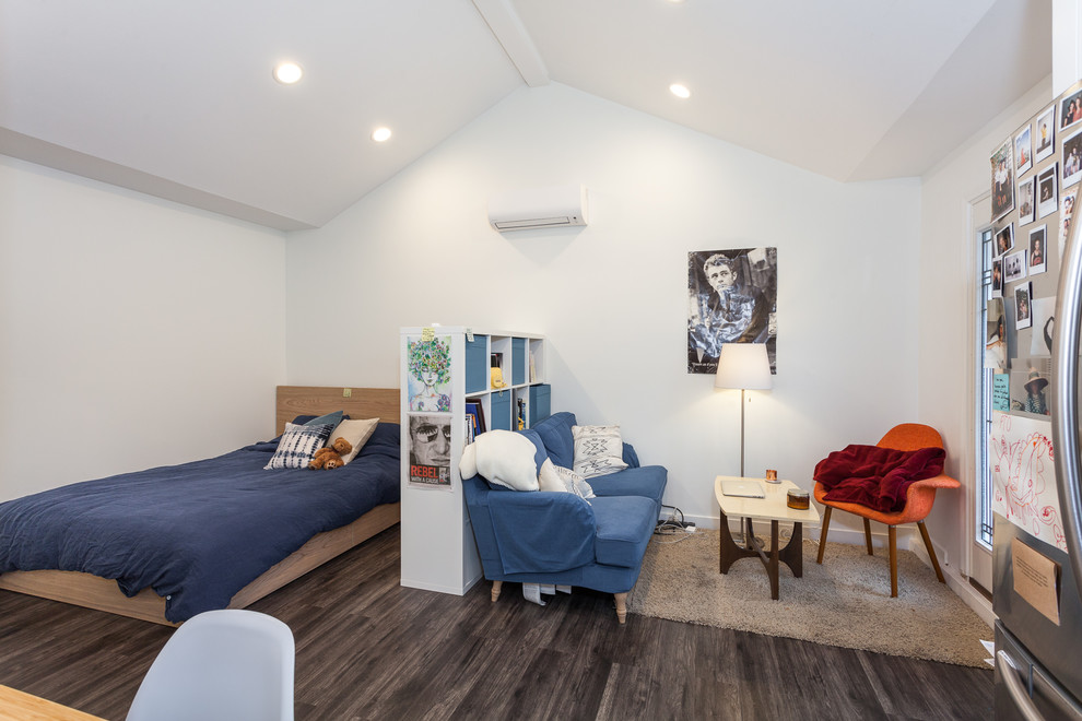Imagen de dormitorio principal contemporáneo de tamaño medio con paredes blancas, suelo laminado y suelo marrón