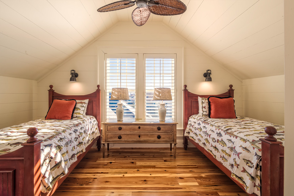 チャールストンにある小さなビーチスタイルのおしゃれな客用寝室 (ベージュの壁、無垢フローリング、暖炉なし、茶色い床、勾配天井) のレイアウト